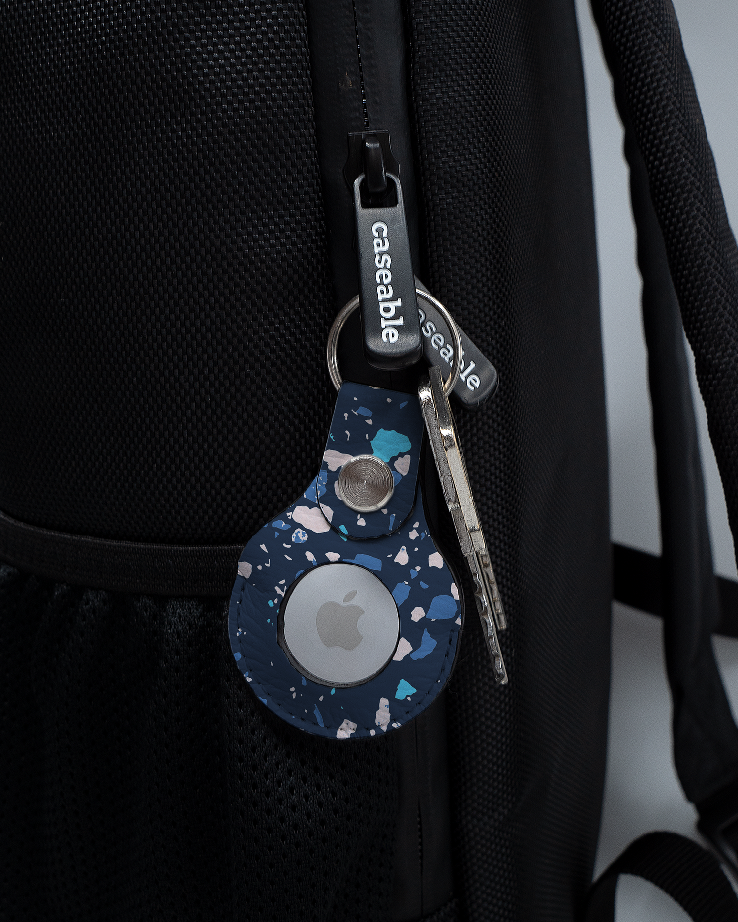 AirTag Anhänger mit Motiv Speckled Marble an einem Rucksack agebracht