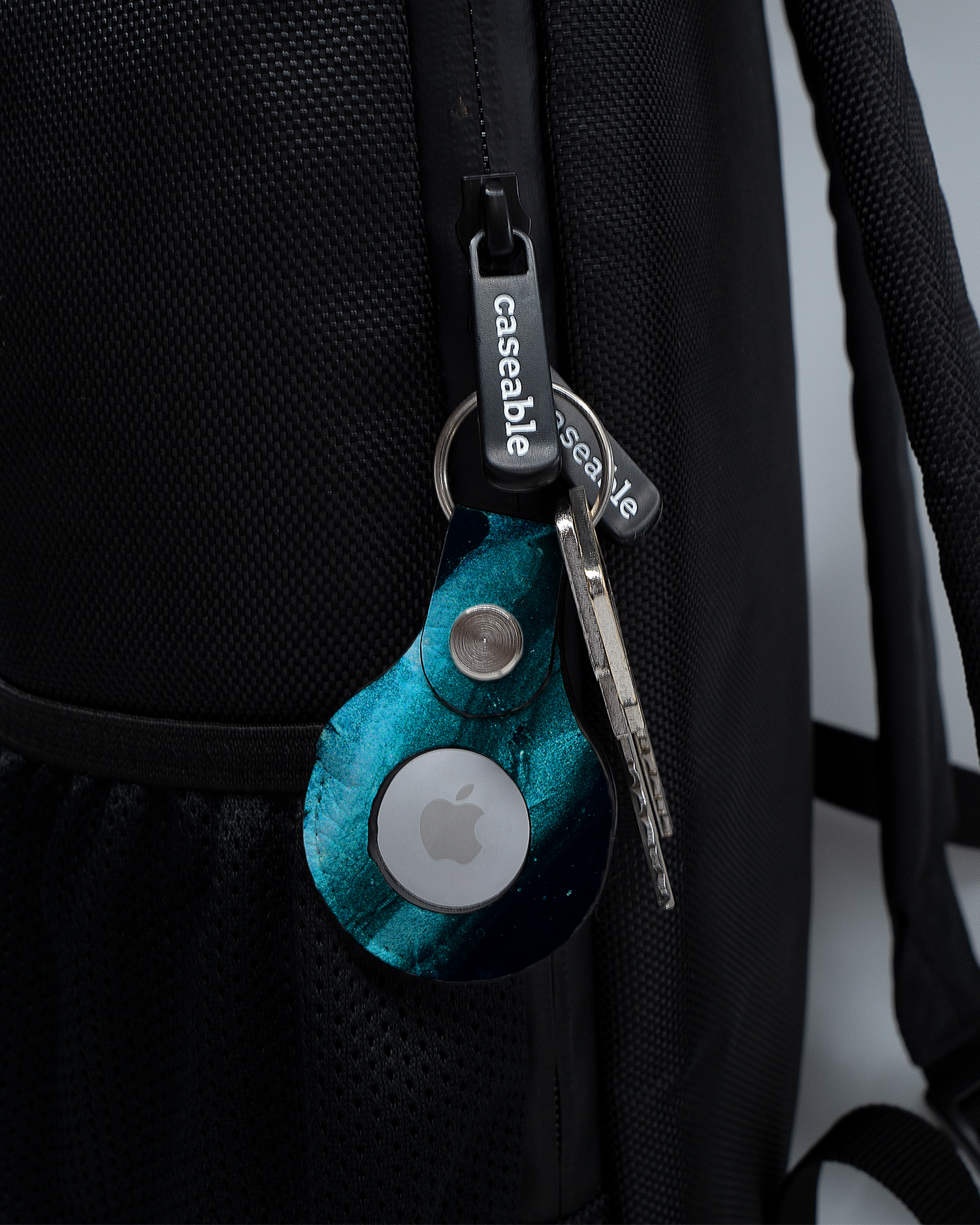 AirTag Anhänger mit Motiv Deep Turquoise Sparkle an einem Rucksack agebracht