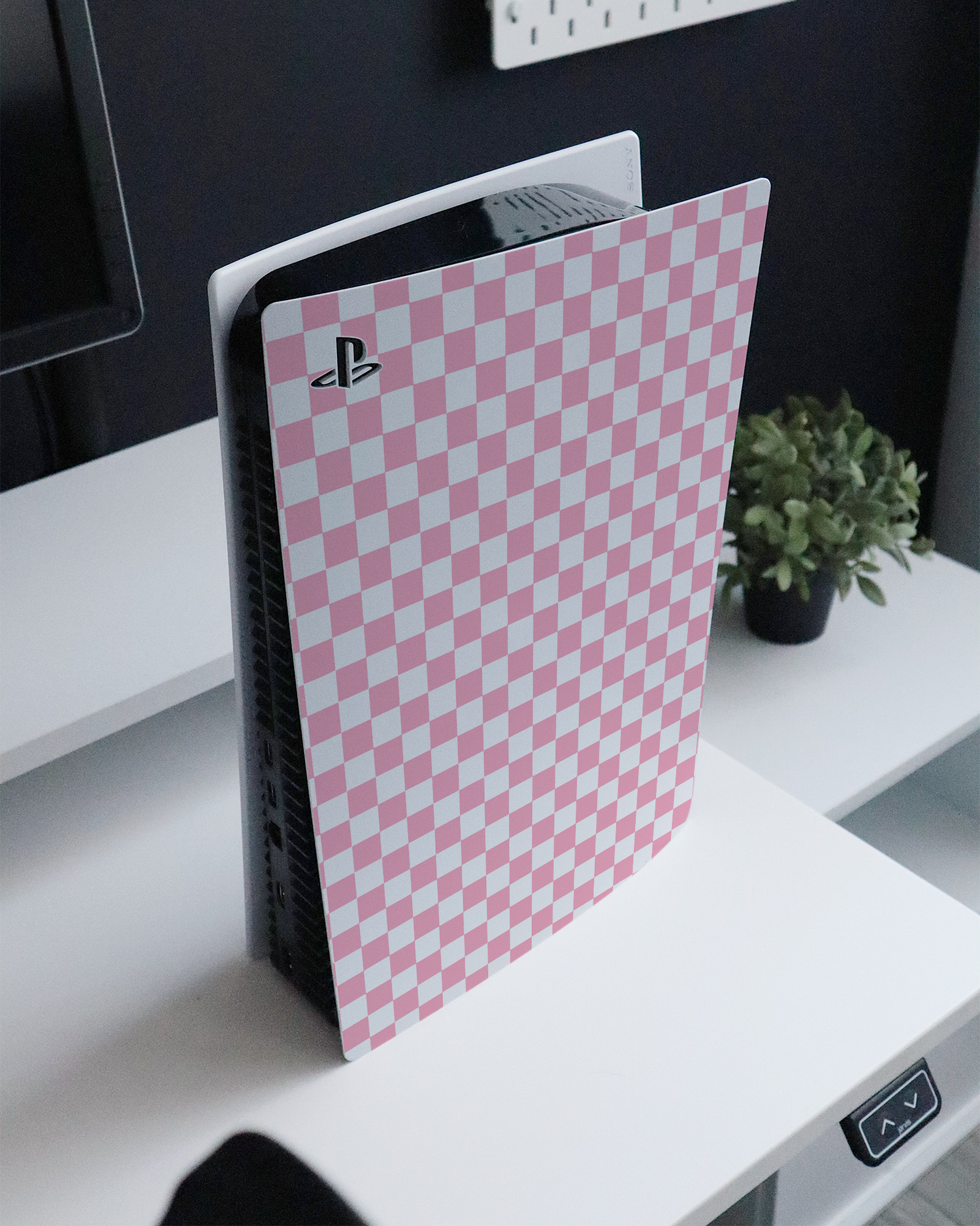 Pink Checkerboard Konsolen Aufkleber für Sony PlayStation 5 Digital Edition auf einem Sideboard
