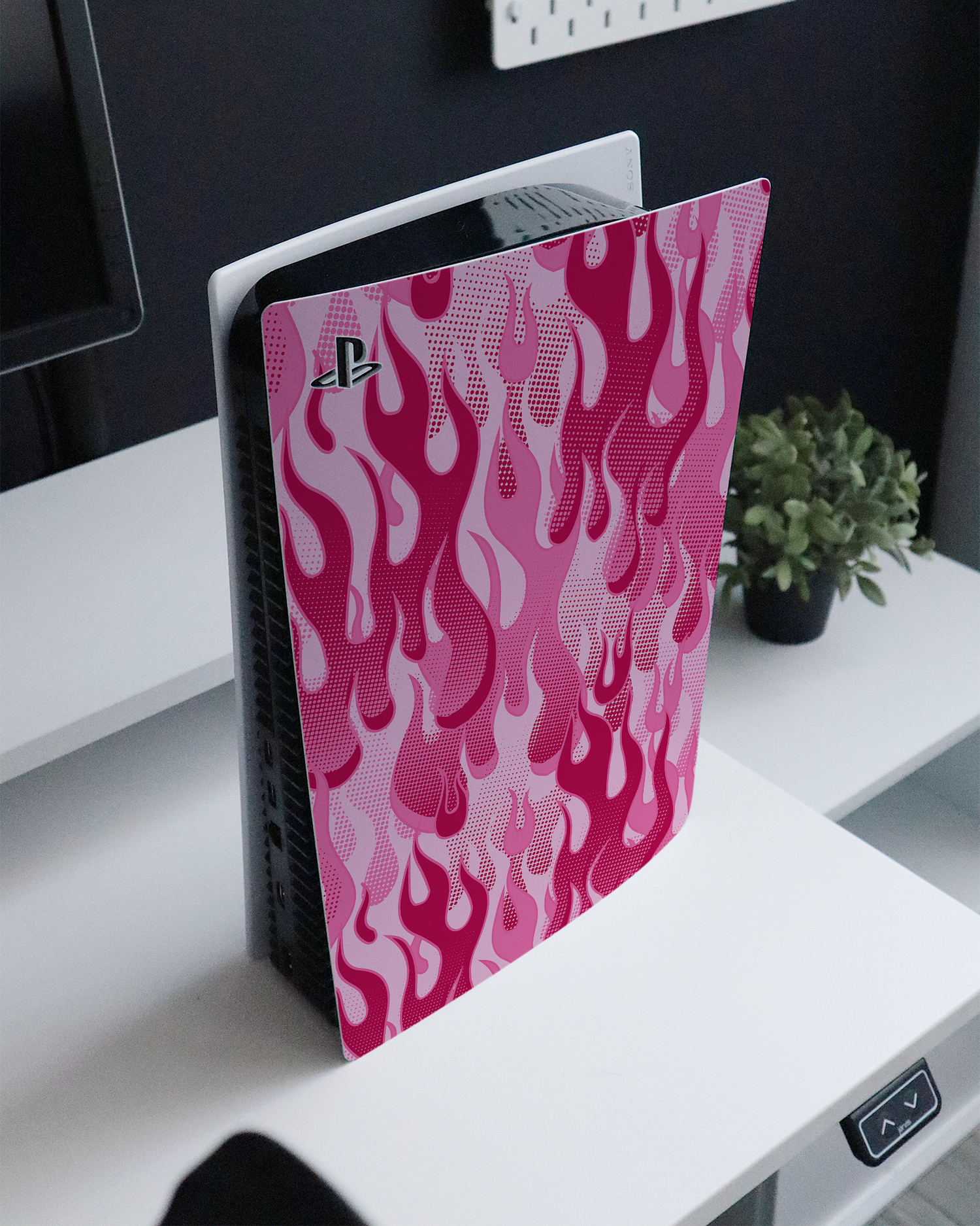 Pink Flames Konsolen Aufkleber für Sony PlayStation 5 Digital Edition auf einem Sideboard