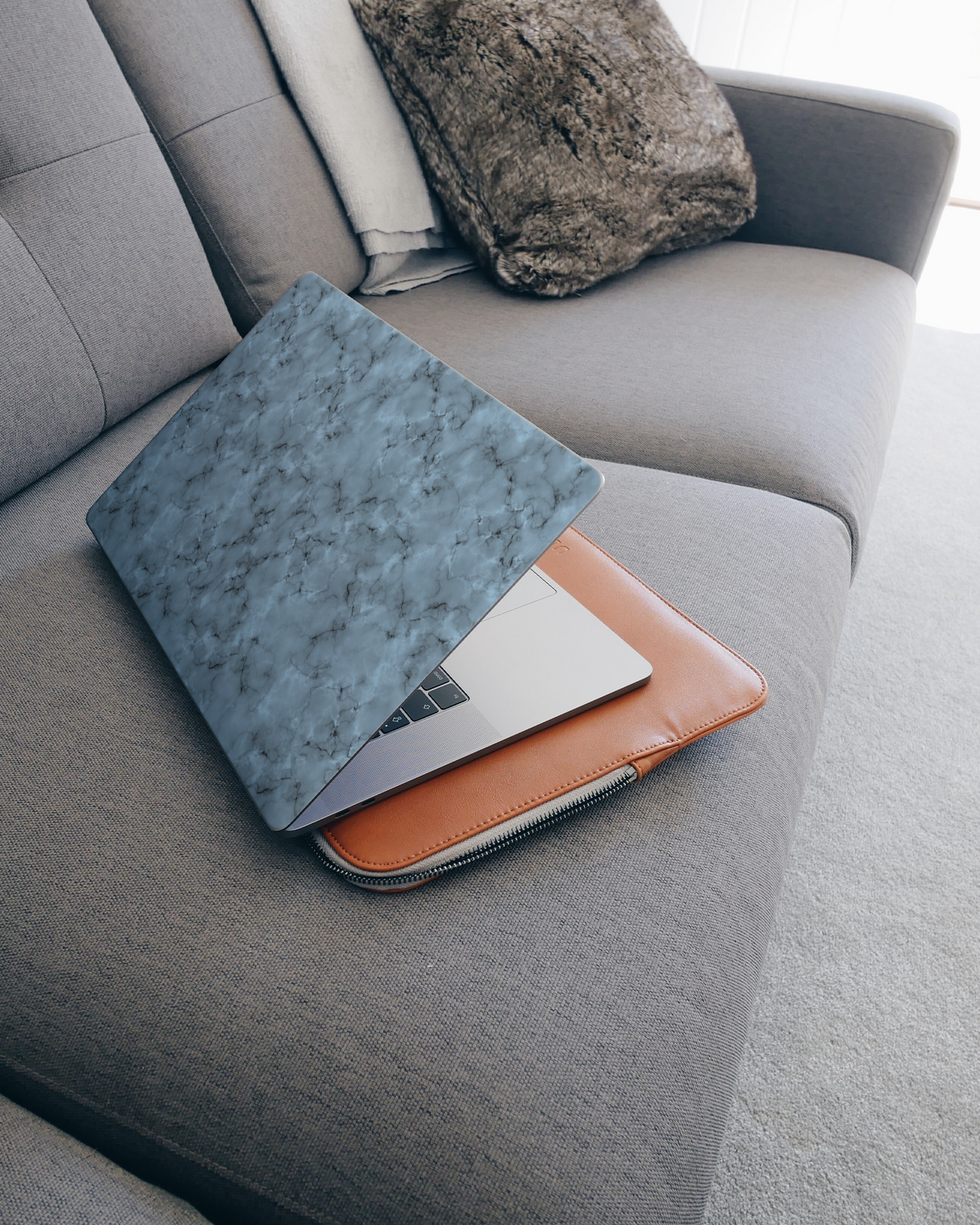 Blue Marble Laptop Aufkleber für 15 Zoll Apple MacBooks auf dem Sofa