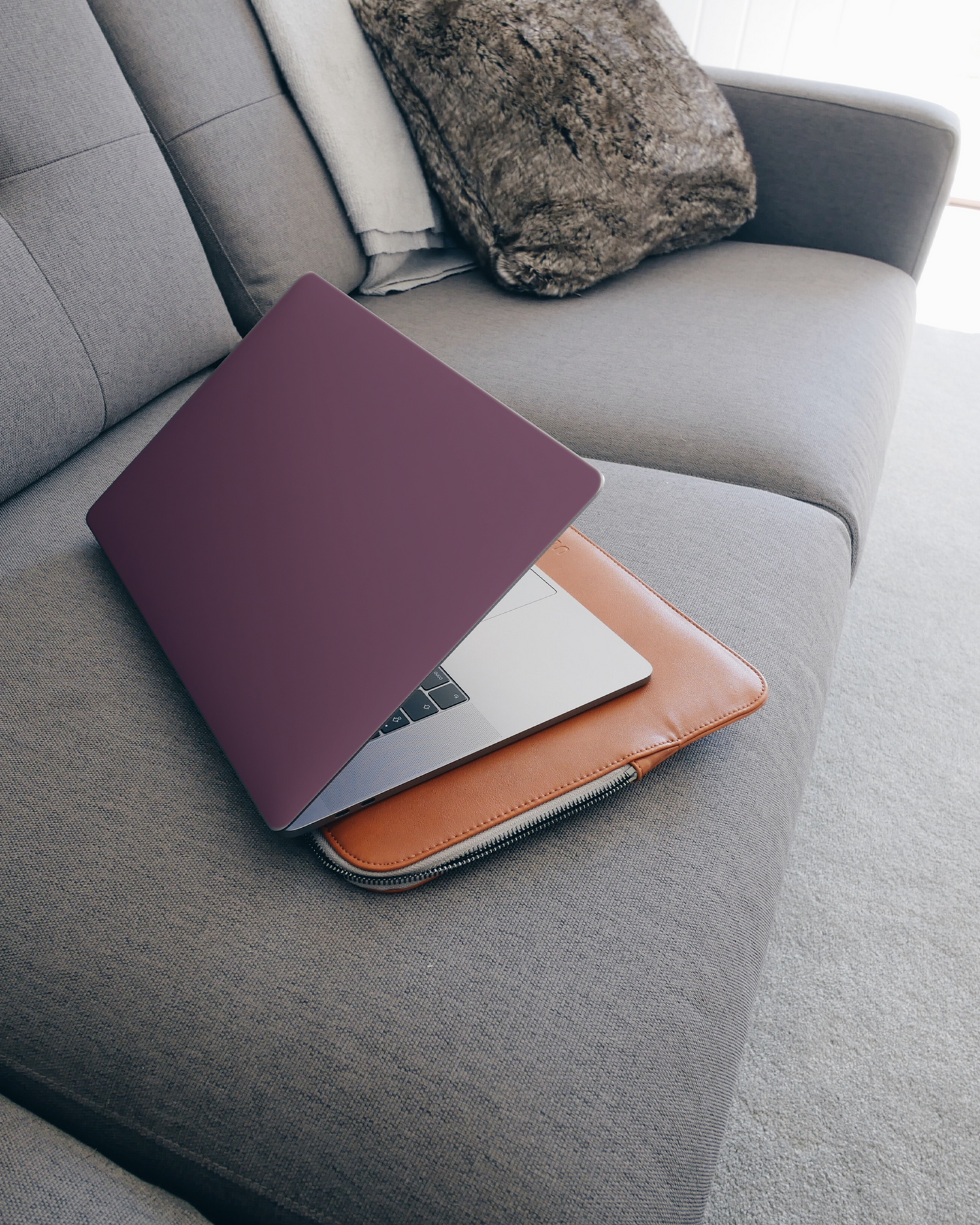 PLUM Laptop Aufkleber für 15 Zoll Apple MacBooks auf dem Sofa