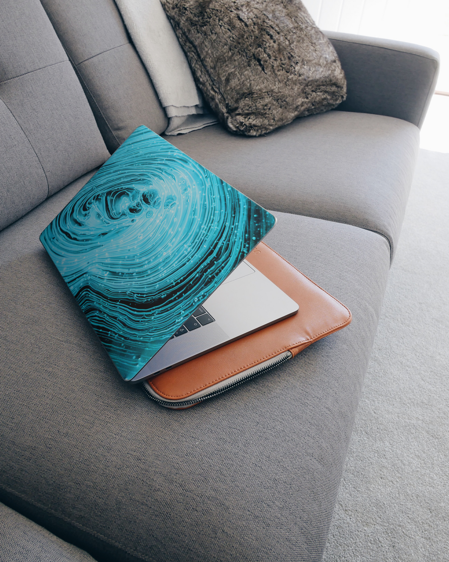 Turquoise Ripples Laptop Aufkleber für 15 Zoll Apple MacBooks auf dem Sofa