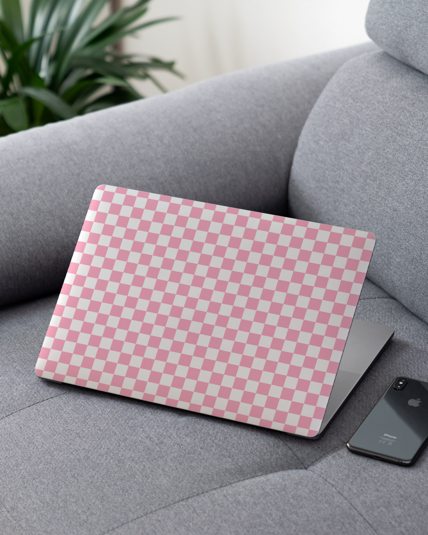 Pink Checkerboard Laptop Aufkleber für 13 Zoll Apple MacBooks auf dem Sofa